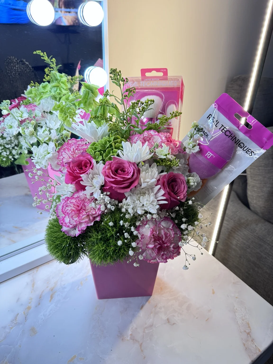 Pink roses and purple textured blooms in a floral design